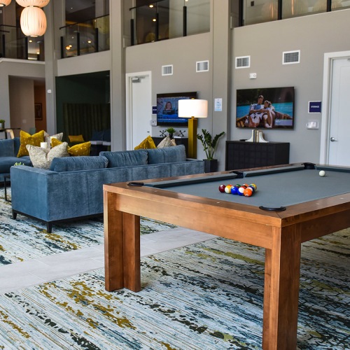 Spacious and well lit clubhouse with plenty of seating and shuffle board and billiards tables.