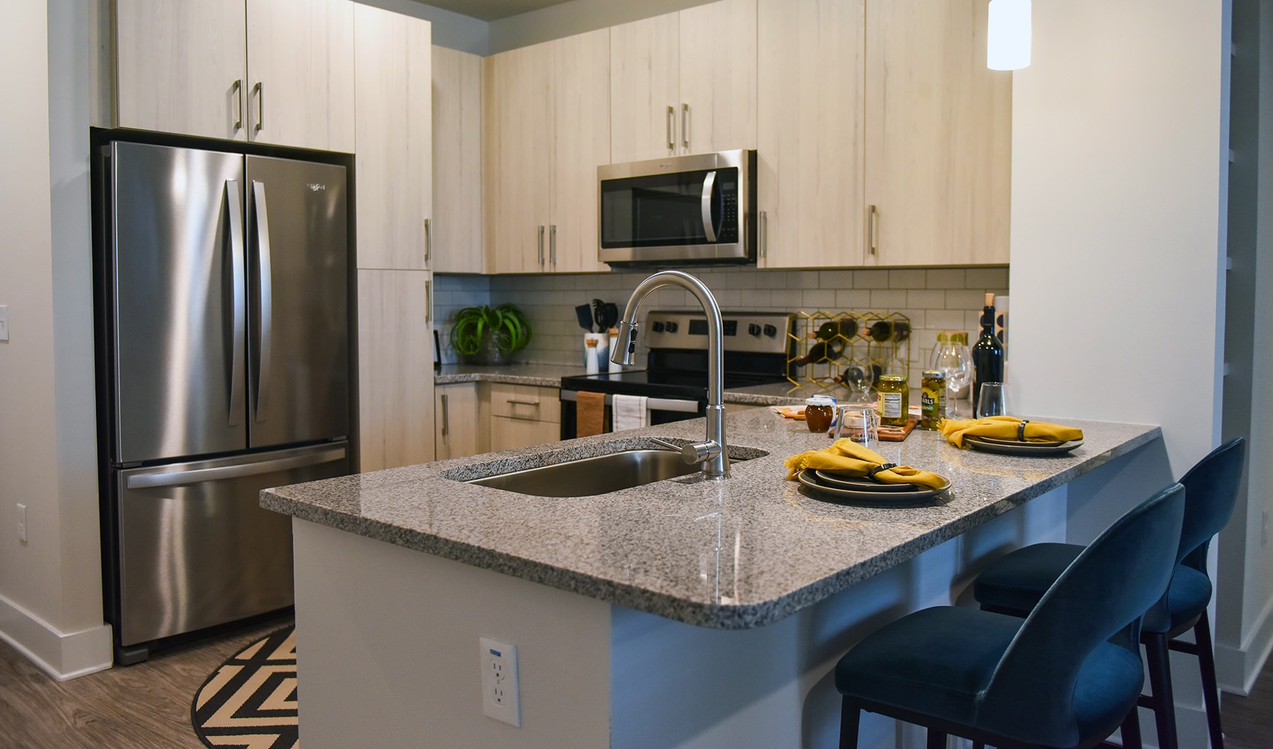 Kitchen  Spacious and well lit kitchen with wood floors and stainless steel appliances.